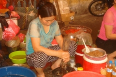 Vietnam, femme qui écrase au pilon pour faire une pâte